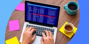 Person working on laptop with colorful notes and coffee.